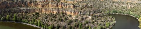 imagen de paisaje en el que discurre un río y se aprecia la ladera erosionada de la montaña